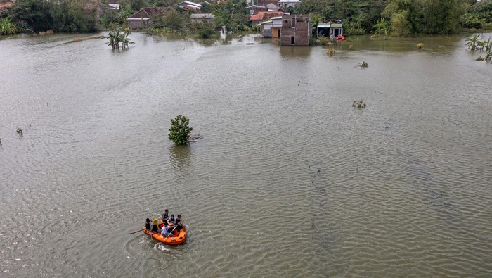 Sawah di Demak Terendam Banjir, Petani Terancam Gagal Panen Foto udara sejumlah warga mendayung perahu karet di sekitar areal persawahan yang terendam banjir Di Desa Prampelan, Kecamatan Sayung, Kabupaten Demak, Jawa Tengah, Selasa (3/1/2023). Menurut data yang dihimpun BPBD Kabupaten Demak per Senin (2/1) pukul 20:00 WIB sebanyak 4.306 hektare sawah di 14 kecamatan di Kabupaten Demak terendam banjir akibat luapan sejumlah sungai yang tak mampu menampung debit air karena intensitas hujan tinggi sejak Sabtu (31/12/2022) dini hari. ANTARA FOTO/Aji Styawan/foc.