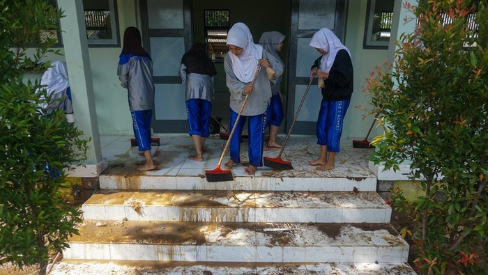 Petugas pemadam kebakaran membersihkan lumpur sisa banjir di SMP N 9, Kabupaten Batang, Jawa Tengah, Rabu (4/1/2023). Sekolah melibatkan siswa dan pemadam kebakaran untuk membersihkan lumpur sisa banjir akibat hujan deras yang terjadi pada Sabtu (31/12/2022) dan Senin (2/1/2023) itu. ANTARA FOTO/Harviyan Perdana Putra/rwa.