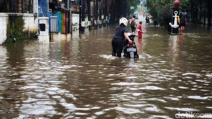 Banjir yang merendam perempatan Seskoal Cipulir, Jakarta Selatan, cukup tinggi. Pemotor yang nekat menerobos pun mogok.