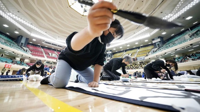 Participants show their traditional Japanese calligraphy during the annual New Year's calligraphy contest at the Budokan martial arts hall Thursday, Jan. 5, 2023, in Tokyo. (AP Photo/Eugene Hoshiko)