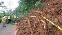 Sejumlah warga bersama relawan menyingkirkan material tanah longsor yang menutupi sebagian jalan alternatif Semarang-Temanggung di Kalimanggis, Kaloran, Temanggung, Jawa Tengah.