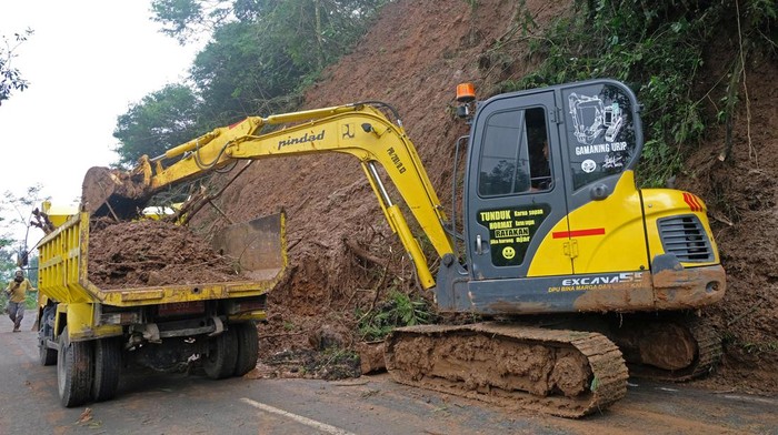 Sejumlah warga bersama relawan menyingkirkan material tanah longsor yang menutupi sebagian jalan alternatif Semarang-Temanggung di Kalimanggis, Kaloran, Temanggung, Jawa Tengah, Kamis (5/1/2023). Hujan lebat sepanjang hari Rabu (4/1/2023) menyebabkan longsor di empat lokasi yang mengakibatkan sejumlah rumah rusak dan menutup jalan Semarang-Temanggung.
