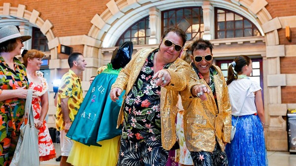 Lusinan penggemar Elvis Presley membanjiri Stasiun Utama Sydney sejak Rabu (4/1) pagi. Mereka menggunakan jas berkobar yang dihiasi payet emas, serta wig hitam untuk mengikuti Festival Elvis Presley tahunan ke-30 di sebuah kota pedesaan kecil di NSW. Â Lusinan penggemar Elvis Presley membanjiri Stasiun Utama Sydney sejak Rabu (4/1) pagi. Mereka menggunakan jas berkobar yang dihiasi payet emas, serta wig hitam untuk mengikuti Festival Elvis Presley tahunan ke-30 di sebuah kota pedesaan kecil di NSW. Â