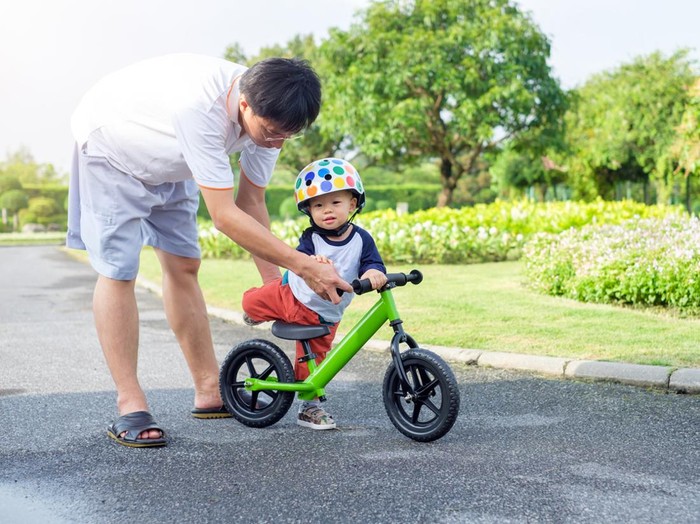 Young father spend time with Cute little Asian 18 months / 1 year old toddler boy child, Dad and son play and have fun with balance bike (run bike), Dad tech son to ride bike, fathers day concept