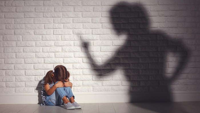 domestic violence. angry mother scolds   frightened daughter sitting on floor