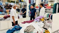 Saat melewati sebuah outlet pakaian lokal Hammer, Jokowi bersama para menteri kemudian memasuki outlet tersebut dan memilih-milih sejumlah pakaian. Jokowi, Pratikno, dan Basuki membeli sweater berwarna merah marun. Sementara itu, Erick Thohir memilih sebuah jaket berwarna putih biru. (Laily Rachev/Biro Pers Sekretariat Presiden)