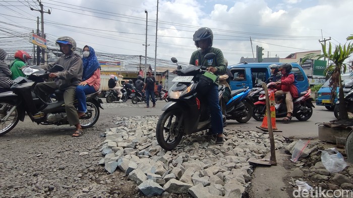 Lubang-lubang di Jl Mayor Oking pertigaan Cibinong Mall mulai ditambal dengan bebatuan. 5 Januari 2023. (Rizky Adha Mahendra/detikcom)