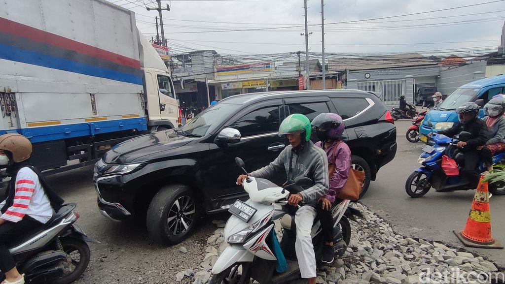Lubang-lubang di Jl Mayor Oking pertigaan Cibinong Mall mulai ditambal dengan bebatuan. 5 Januari 2023. (Rizky Adha Mahendra/detikcom)