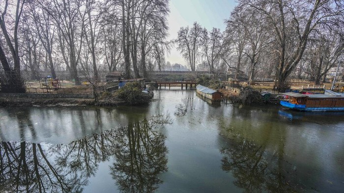 Musim Dingin Bikin Danau Dal di Srinagar Membeku, Begini Potretnya A Kashmiri boatman moves his boat through the frozen surface water of Dal Lake on a cold morning in Srinagar, Indian controlled Kashmir, Wednesday, Jan. 4 , 2022. (AP Photo/Mukhtar Khan)