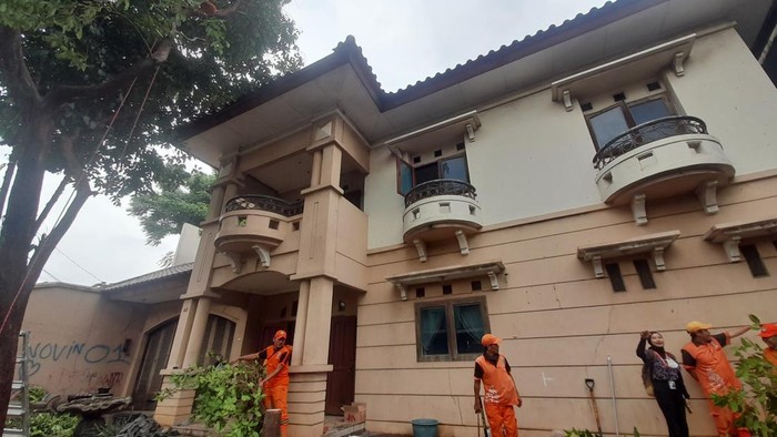 Petugas PPSU pangkas pohon rimbun di halaman depan rumah terbengkalai milik Ibu Eny.