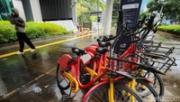 Warga melintas di depan sepeda sewaan yang masih tersisa di sejumlah titik di Jalan Jend. Sudirman, Jakarta Pusat, Kamis (05/01/2023).