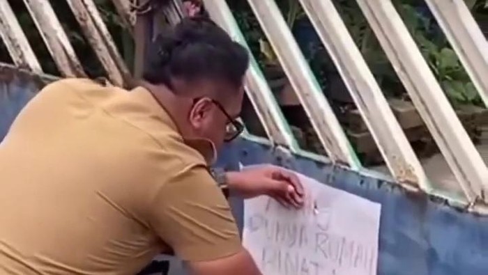 Aksi ASN di Palembang tempel tulisan Binatang ke rumah warga (Foto: Tangkapan layar video viral)