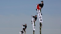 Anggota pemadam kebakaran Jepang beratraksi di atas tangga bambu selama perayaan Tahun Baru di Tokyo, Jepang, Jumat (6/1/2023).