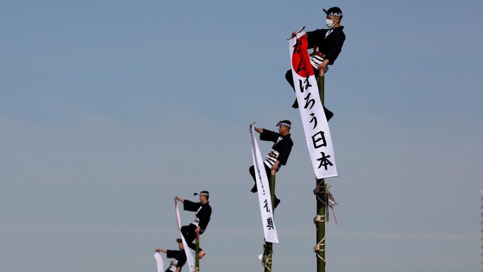 A member of the Edo Firemanship Preservation Association displays his balancing skills atop a bamboo ladder during Tokyo Fire Department's New Year's Fire review in Tokyo, Japan January 6, 2023.  REUTERS/Issei Kato