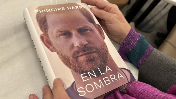 A woman holds a copy of 