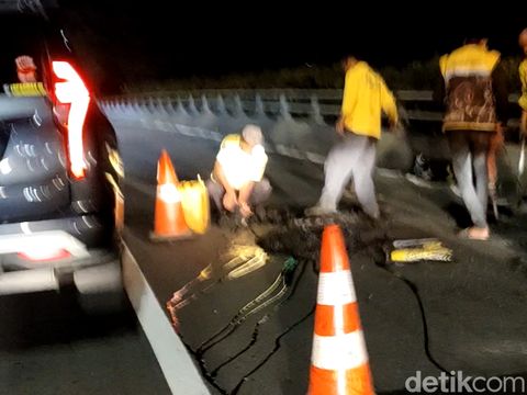 Perbaikan lubang jalan di Flyover Pancoran arah Cawang, Kamis (5/1/2023) malam. (Jabbar Ramdhani/detikcom)