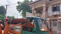 Saat ini, tampak petugas Pasukan Oren bekerja di sekitar rumah mewah Ibu Eny untuk melakukan pembersihan sisa-sia sampah setelah kemarin rumah tersebut dibersihkan. Foto: (Shafira Cendra Arini/detikcom)