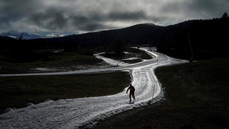 A man practices nordic skiing despite the lack of snow in La Feclaz, near Chambery, in the French Alps, Thursday, Jan. 5, 2023. (AP Photo/Laurent Cipriani)
