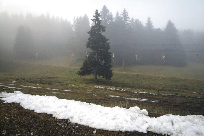 A man practices nordic skiing despite the lack of snow in La Feclaz, near Chambery, in the French Alps, Thursday, Jan. 5, 2023. (AP Photo/Laurent Cipriani)