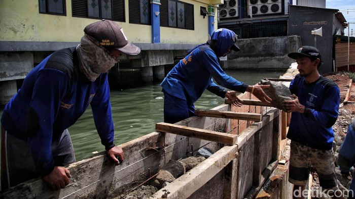 Petugas Sudin Sumber Daya Air melakukan peninggian tanggul di kawasan Resto Apung, Pelabuhan Muara Angke, Penjaringan, Jakarta Utara, Jumat (6/1/2023).