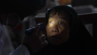 Petugas kesehatan memeriksa mata warga saat pemeriksaan kesehatan gratis di Sentra Ikan Bulak, Surabaya, Jawa Timur, Jumat (06/01/2023).
