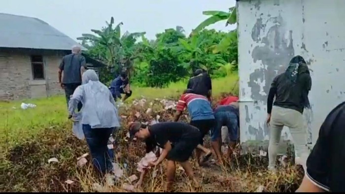 Warga mengutip uang yang berserakan di Padang Pariaman Warga mengutip uang yang berserakan di Padang Pariaman