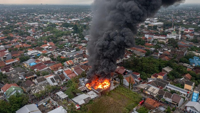 Sejumlah mobil pemadam kebakaran dan sebuah kendaraan meriam air kepolisian berupaya memadamkan kobaran api yang membakar gudang cairan tiner di Kelurahan Pedurungan Tengah, Kecamatan Pedurungan, Semarang, Jawa Tengah, Sabtu (7/1/2023). Kebakaran yang sempat disertai bunyi ledakan dari dalam gudang tersebut terjadi sejak sekitar pukul 16:15 WIB, dan sebanyak 12 mobil pemadam kebakaran Kota Semarang serta satu mobil meriam air kepolisian dikerahkan dalam upaya memadamkan kobaran api. ANTARA FOTO/Aji Styawan/tom.