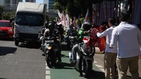 Para kader memberikan kaos gratis kepada sejumlah pengendara yang melintas.