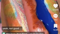Hot dog biasanya dibuat dengan roti polos panjang berisikan sosis yang diberikan mustard dan saus tomat. Menu hot dog satu ini sangat berbeda, rotinya berwarna pelangi, lalu diberikan saus berwarna biru elektrik. Foto: TikTok @wrightdownmainstreet