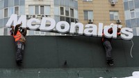 Pekerja mencopot papan logo McDonald’s di Almaty, Kazakhstan, Jumat (6/1/2023).