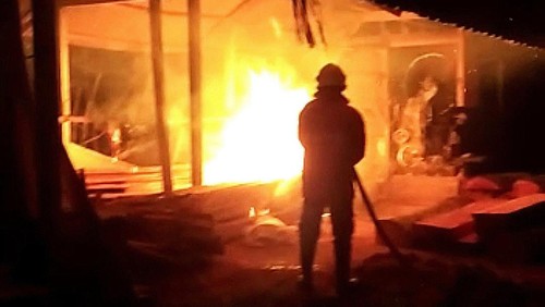 Petugas Damkartan Karangasem saat melakukan pemadaman api yang membakar gudang kayu di Desa Duda, Karangasem, Bali, Sabtu (7/1/2023) dini hari.