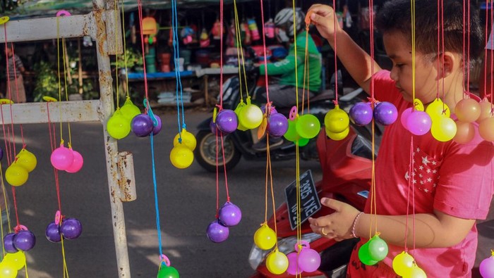 Pembeli memilih permainan lato-lato yang dijual di Cibinong, Kabupaten Bogor, Jawa Barat, Jumat (6/1/2023). Menurut pedagang alat permainan lato-lato tersebut dijual dengan harga Rp10 ribu hingga Rp20 ribu dan dalam sehari pedagang mampu meraup keuntungan hingga Rp500 ribu karena permainan tersebut sedang tren di kalangan anak-anak. (ANTARA FOTO/Yulius Satria Wijaya)