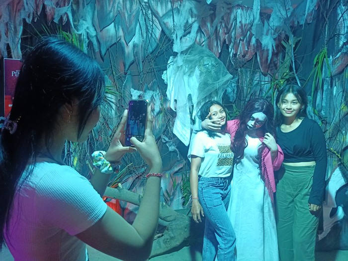 Sejumlah pengunjung berfoto dengan hantu di wisata horor, di Ramayana Mall Bali, Sabtu (7/1/2023)