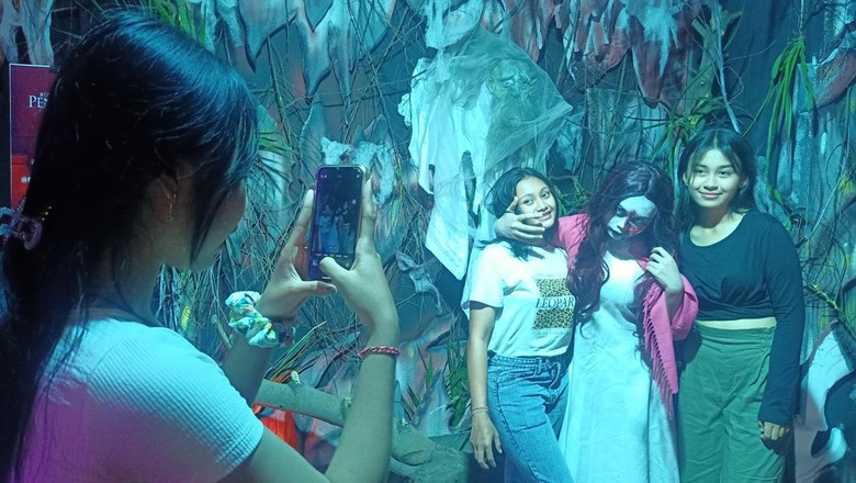 Sejumlah pengunjung berfoto dengan hantu di wisata horor, di Ramayana Mall Bali, Sabtu (7/1/2023)