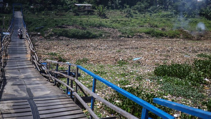 Sungai Citarum Bandung Kembali Dipadati Sampah Warga melintasi bantaran Sungai Citarum yang dipenuhi sampah di Batujajar, Kabupaten Bandung Barat, Jawa Barat, Jumat (6/1/2023). Warga di kawasan tersebut tetap memanfaatkan sumber daya alam aliran Sungai Citarum, meski kondisinya yang mulai kembali dipenuhi oleh sampah dan berwarna hitam. ANTARA FOTO/Raisan Al Farisi/aww.
