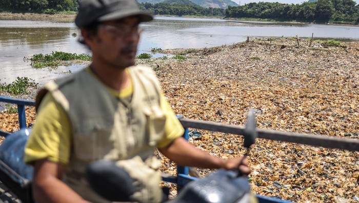 Warga melintasi bantaran Sungai Citarum yang dipenuhi sampah di Batujajar, Kabupaten Bandung Barat, Jawa Barat, Jumat (6/1/2023). Warga di kawasan tersebut tetap memanfaatkan sumber daya alam aliran Sungai Citarum, meski kondisinya yang mulai kembali dipenuhi oleh sampah dan berwarna hitam. ANTARA FOTO/Raisan Al Farisi/aww.