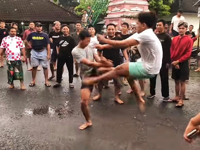 Tangkapan layar saat para pemuda melaksanakan tradisi tamblang waluh di perempatan jalan Desa Adat Bungaya, dua hari sebelum hari raya Galungan. (istimewa)