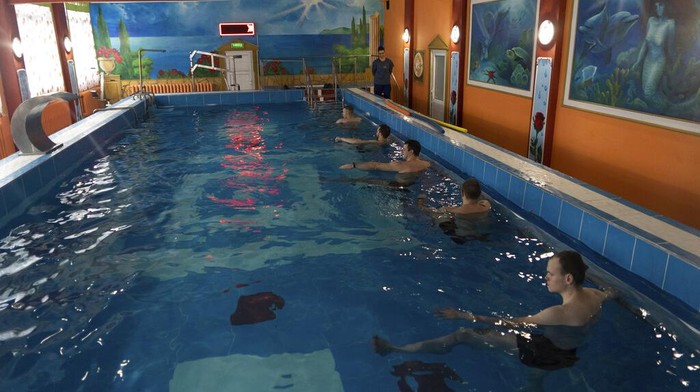 Cara Militer Ukraina Pulihkan Fisik dan Mental di Tengah Invasi Rusia Ukrainian soldier take part in an aquatic therapy session in a hot pool at a rehabilitation center in Kharkiv region, Ukraine, Friday, Dec. 30, 2022. The relentless 10-month war has prompted a local commander to transform an old soviet-era sanatorium into a recovery center for servicemen to treat both mental and physical ailments. (AP Photo/Vasilisa Stepanenko)