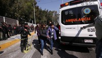 Seorang wanita dibantu untuk mencapai ambulans setelah dua kereta bawah tanah bertabrakan di stasiun kereta bawah tanah. 