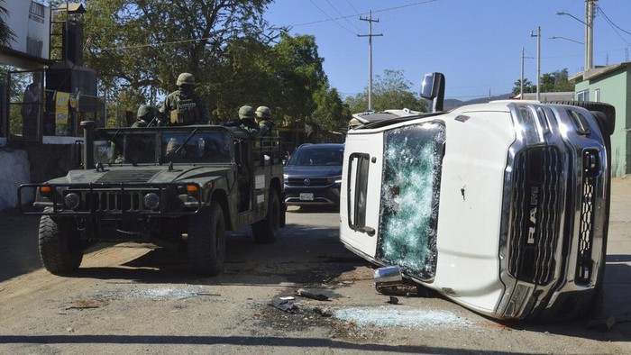 Meksiko Mencekam Diamuk Kartel Narkoba Army soldiers drive past a destroyed vehicle on the streets of Jesus Maria, Mexico, on Saturday, Jan. 7, 2023, the small town where Ovidio Guzman was detained earlier in the week. Thursday's government operation to detain Ovidio, the son of imprisoned drug lord Joaquin