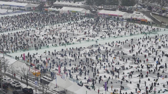Melihat Keseruan Mancing Ikan di Sungai Beku Korea Selatan Participants cast lines through holes drilled in the surface of a frozen river during a trout catching contest in Hwacheon, South Korea, Saturday, Jan. 7, 2023. The contest is part of an annual ice festival which draws over one million visitors every year. (AP Photo/Ahn Young-joon)