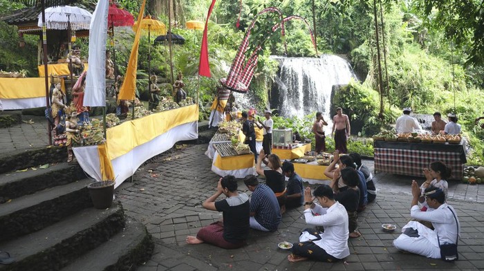Wisatawan melakukan persembahyangan saat mengikuti ritual melukat atau pembersihan diri di Taman Beji Griya Waterfall, Desa Punggul, Badung, Bali, Kamis (5/1/2023). Ritual melukat di objek wisata religi tersebut untuk membersihkan diri dan pikiran secara spiritual dari hal-hal negatif. ANTARA FOTO/Nyoman Hendra Wibowo/rwa.