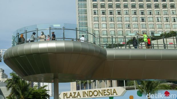 Warga berfoto di anjungan Halte Bundaran HI, Jakarta, Minggu (8/1/2023).