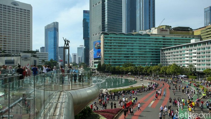 Warga berfoto di anjungan Halte Bundaran HI, Jakarta, Minggu (8/1/2023).