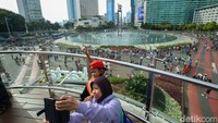 Warga asyik berswafoto di anjungan dengan latar belakang Bundaran HI. 