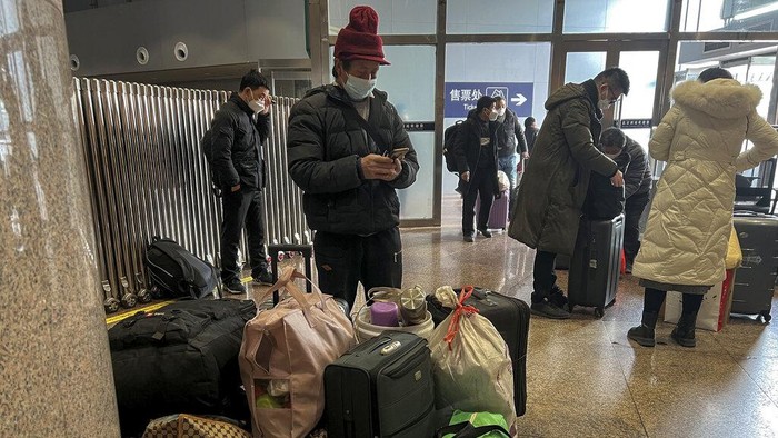 Travellers wearing face masks with their luggage arrive at the West Railway Station in Beijing, Friday, Jan. 6, 2023. China is seeking to minimize the possibility of a major new COVID-19 outbreak during this month's Lunar New Year travel rush following the end of most pandemic containment measures. (AP Photo/Wayne Zhang)