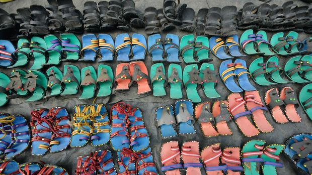 A man is seen working behind a heap of used tires at a street handcraft workshop in Nakuru Town. Approximately 280 million used tires are discarded each year, and only about 30 million of these are retreaded or reused. If not properly managed used tires end up polluting the environment. By repurposing them, artisans in Nakuru and other places are helping keep the waste from getting into the environment. (Photo by James Wakibia / SOPA Images/Sipa USA)No Use Germany.