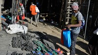 Seorang warga melihat-lihat berbagai model sandal yang terbuat dari ban bekas.