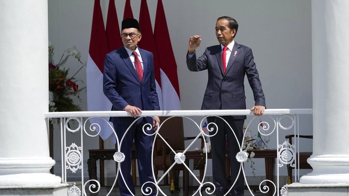 Indonesian President Joko Widod and Malaysias Prime Minister Anwar Ibrahim wave at journalists during their meeting at the presidential palace in Bogor, West Java, Indonesia, Monday, Jan. 9, 2023. (AP Photo/Achmad Ibrahim)