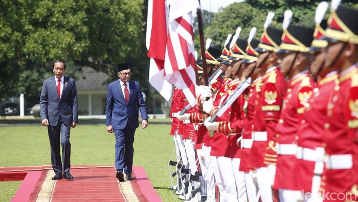 Presiden Joko Widodo dan Perdana Menteri Malaysia Anwar Ibrahim melambaikan tangan kepada wartawan saat bertemu di istana kepresidenan di Bogor, Jawa Barat, Senin (9/1/2023).
